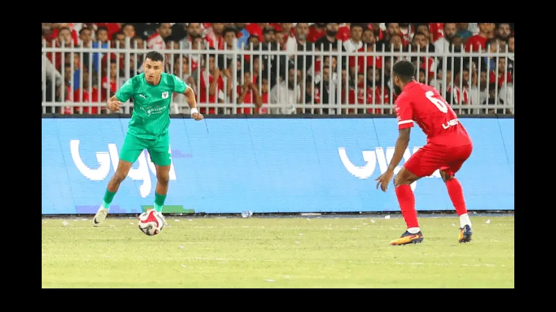 Cầu thủ của Al Ittihad vượt qua hậu vệ Al Masry trong trận đấu bóng đá