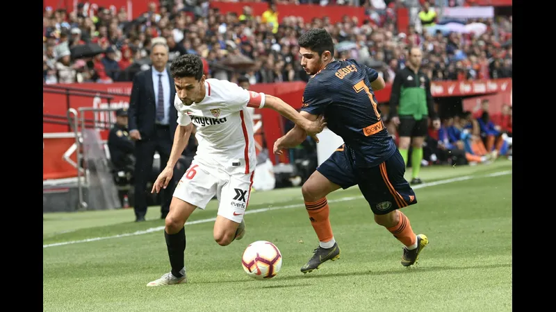 Cầu thủ Valencia vượt qua cầu thủ Sevilla trong trận đấu sôi động. Cầu thủ Valencia vượt qua cầu thủ Sevilla trong trận đấu sôi động.