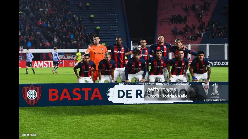 Cầu thủ San Lorenzo dẫn bóng trước sự truy đuổi của Sportivo Trinidense